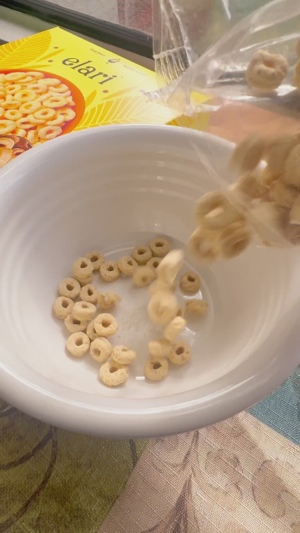 poring elari in a bowl of milk-pour with bananas honey chocolate chip and nuts 